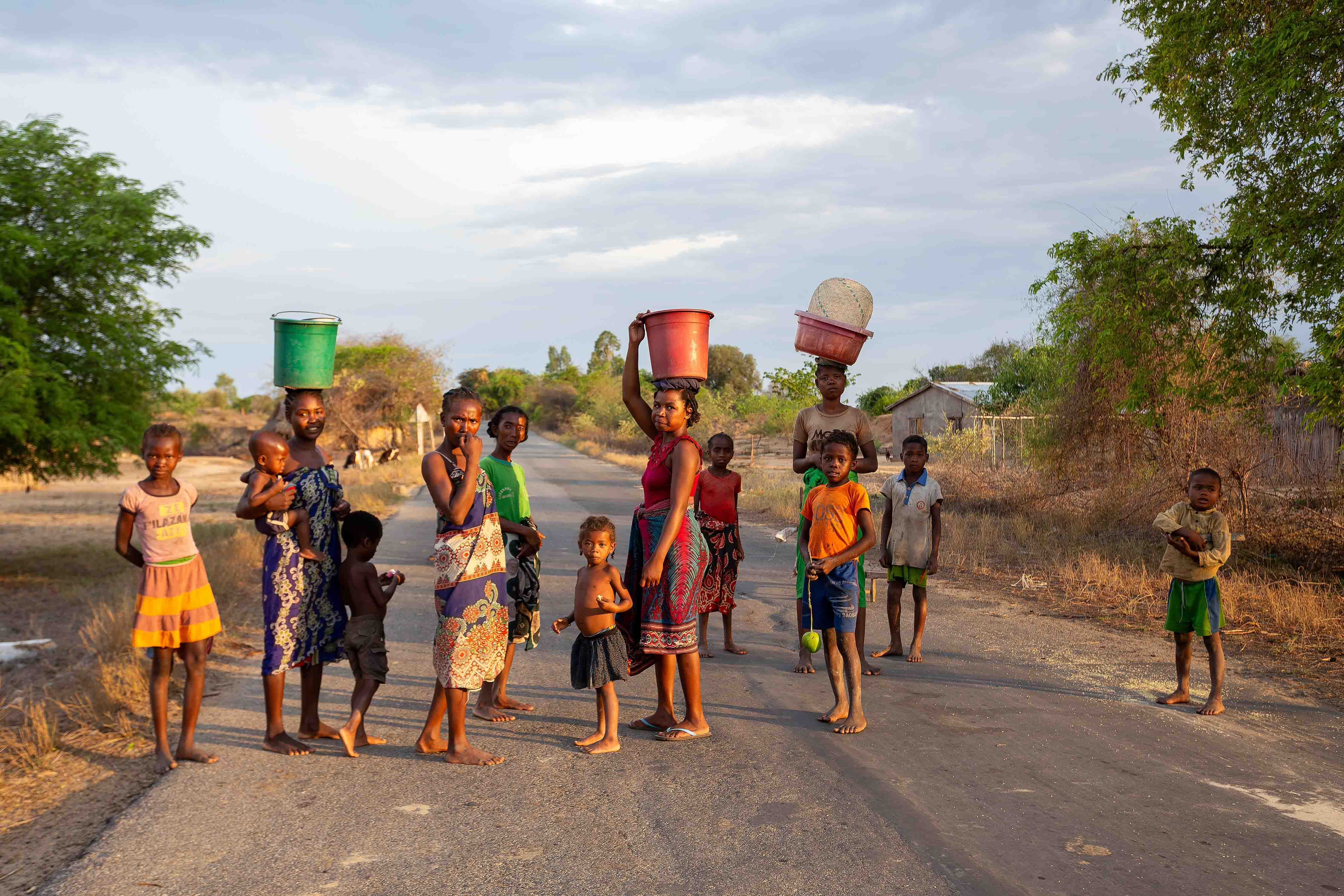 Amkilizato-Mahabo, Madagascar - November 4th 2022: Group of woman with babies in hand and container on head, a common sight in this rural Madagascar village